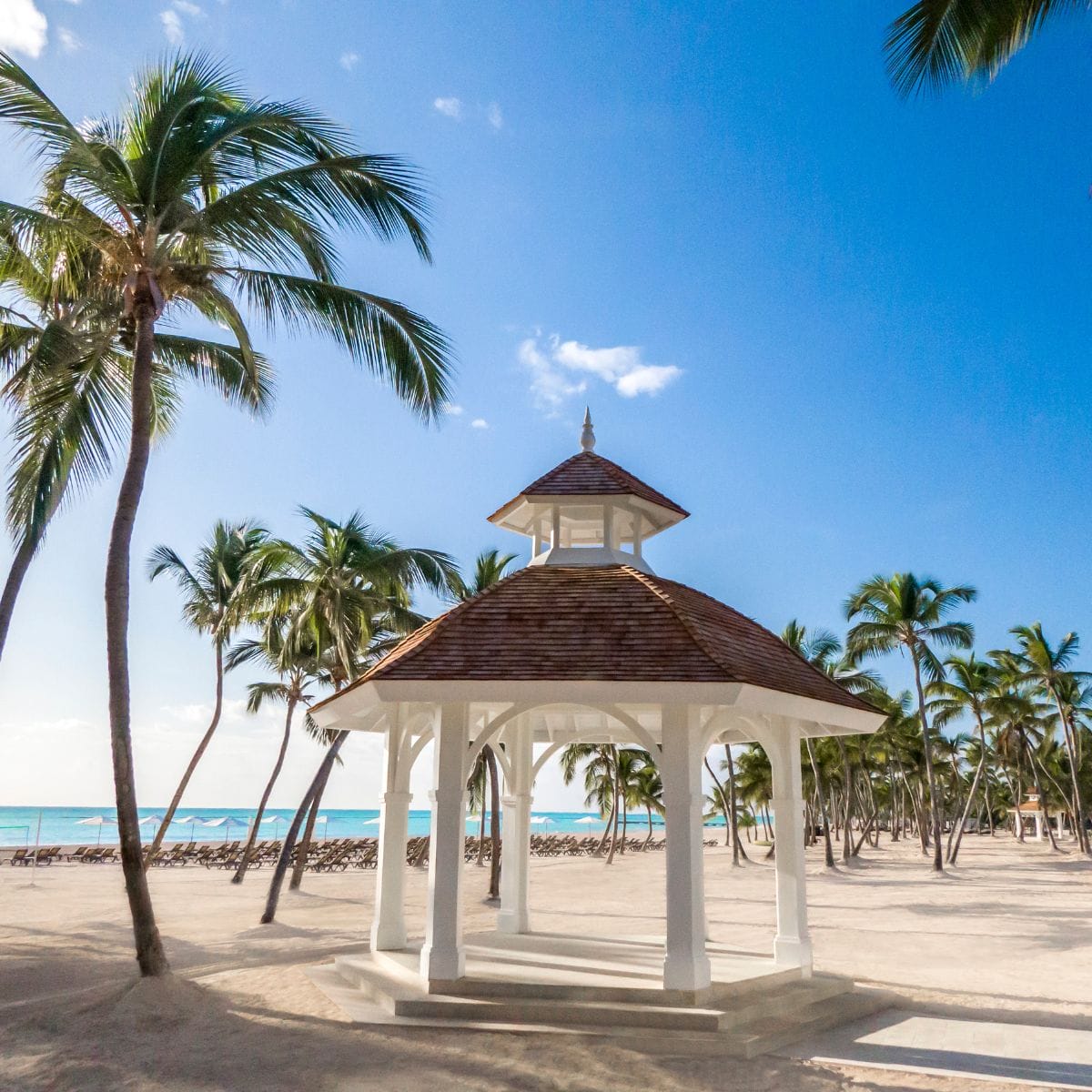 White gazebo on sandy beach, ideal for a romantic destination wedding in the Dominican Republic.
