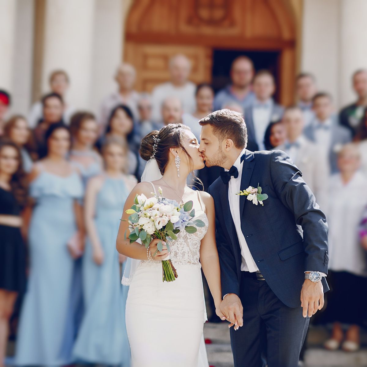 The bride and groom share a kiss while holding hands—a perfect moment for wedding packages designed for 100 guests, ideal for your destination wedding.