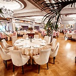 Elegant restaurant dining room, perfect for hosting destination weddings or wedding celebrations of up to 200 guests, featuring sparkling chandeliers for a sophisticated ambiance.