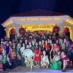 Large group poses by illuminated gazebo at destination wedding event as Destify visits Mexico Caribbean.