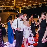 A couple shares a kiss on a glowing dance floor during their destination wedding celebration.