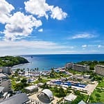 Aerial view of a Caribbean destination wedding resort featuring pools, palm trees, and oceanfront venues.