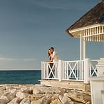 A couple celebrates their destination wedding on a gazebo overlooking the ocean in Jamaica's best month.