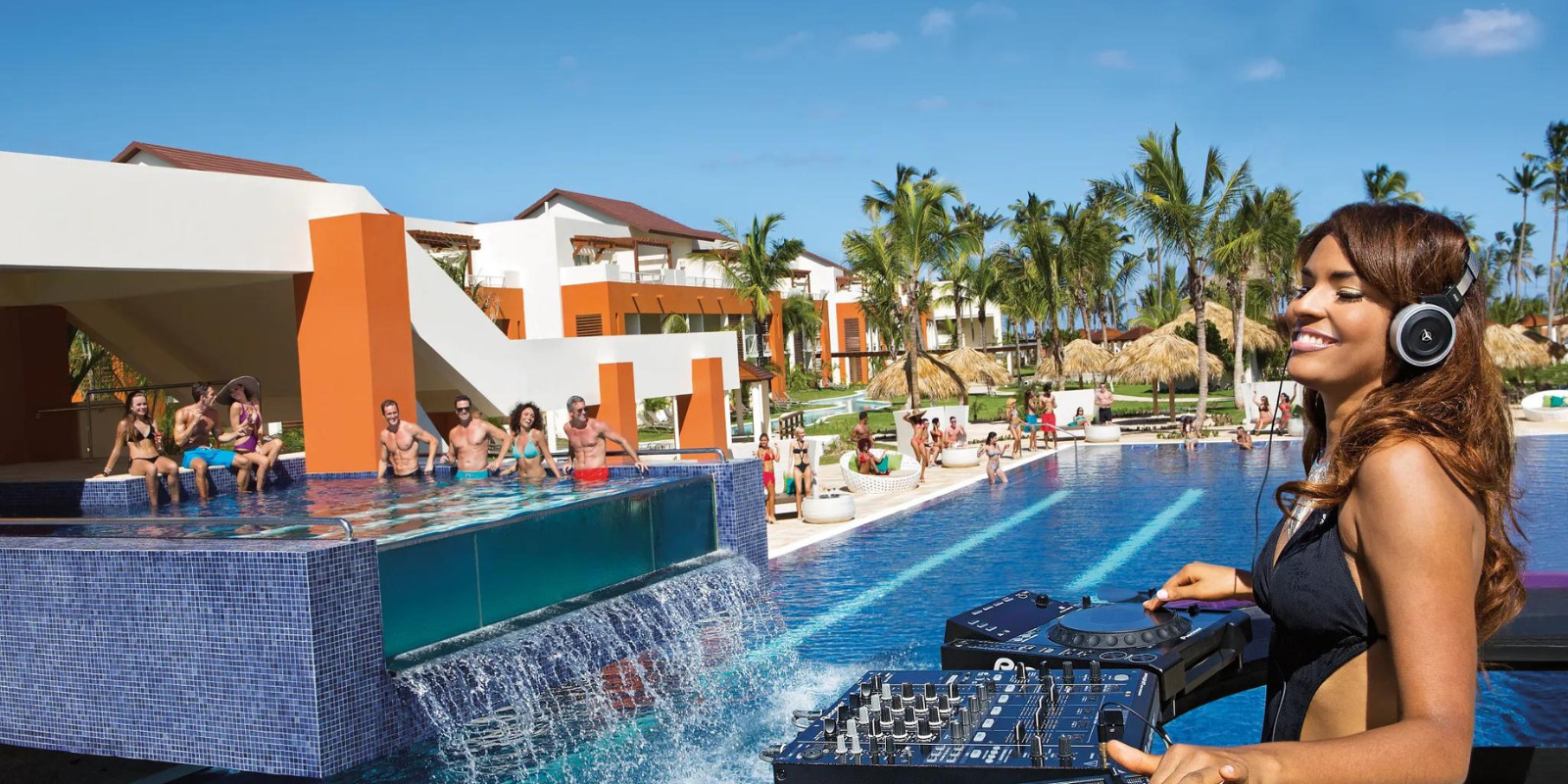A woman with headphones in front of a pool at a wedding with a DJ at Breathless Punta Cana Resort & Spa.