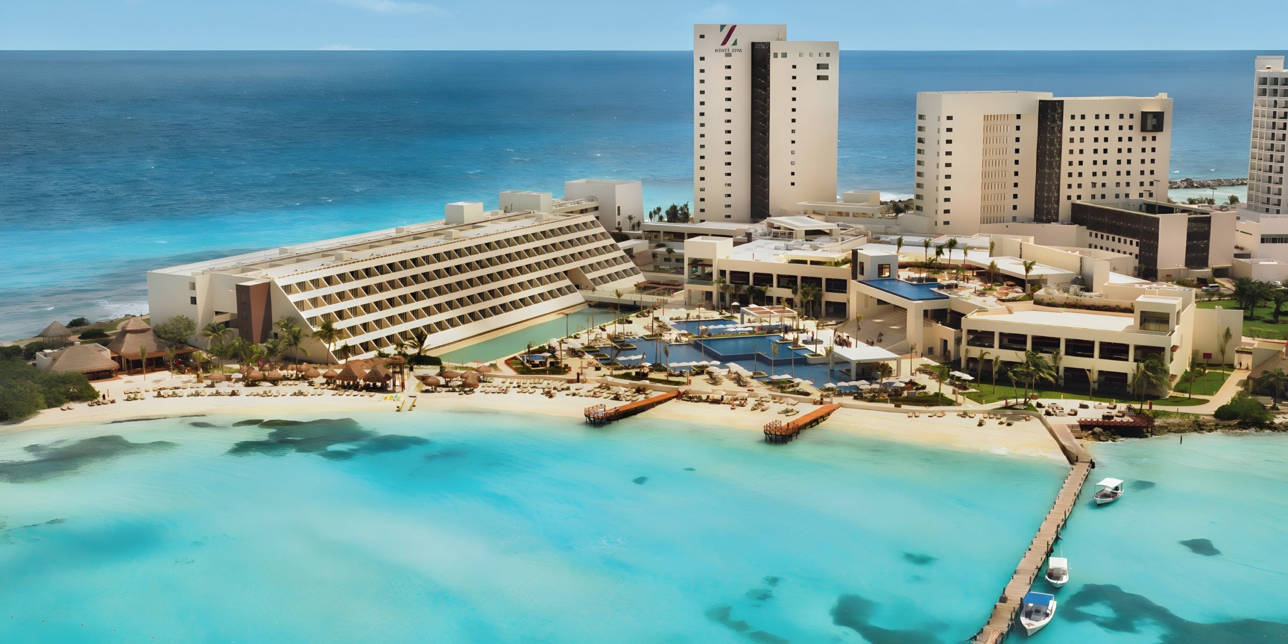 Hyatt Ziva Cancun with beachfront hotels and swimming pools overlooking a turquoise sea.
