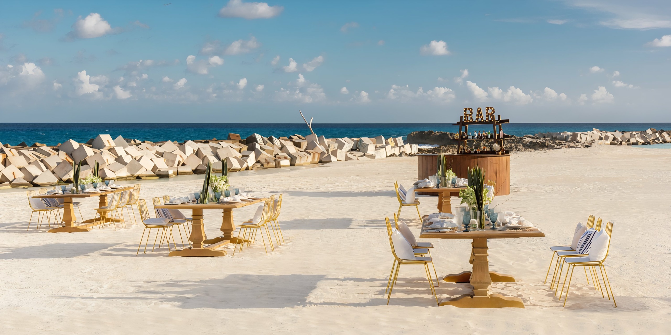 Hyatt Ziva Cancun dining setup with elegantly arranged tables and chairs on sandy shore.