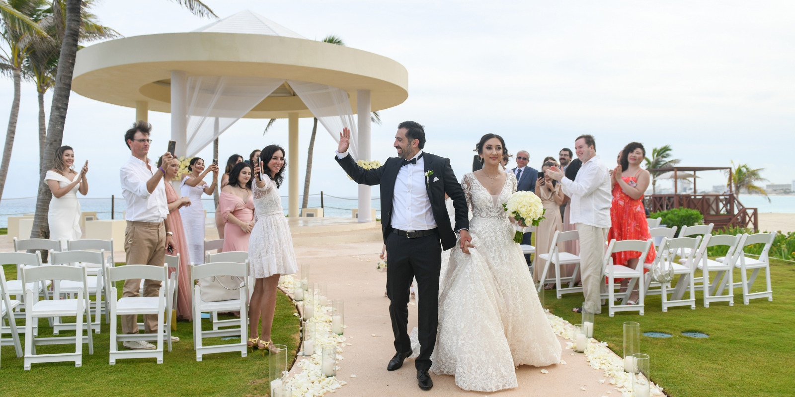 A bride and groom walk down the aisle at a Hyatt Ziva Cancun wedding ceremony.