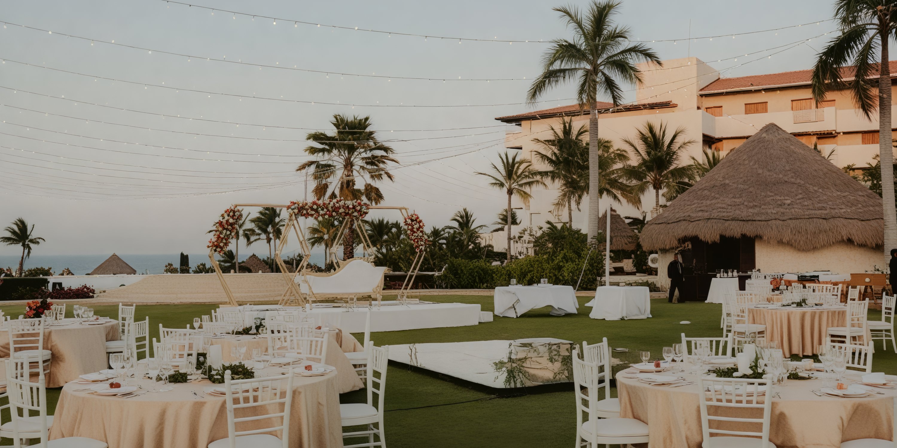 Destination wedding reception featuring round tables and chairs elegantly arranged under romantic string lights.
