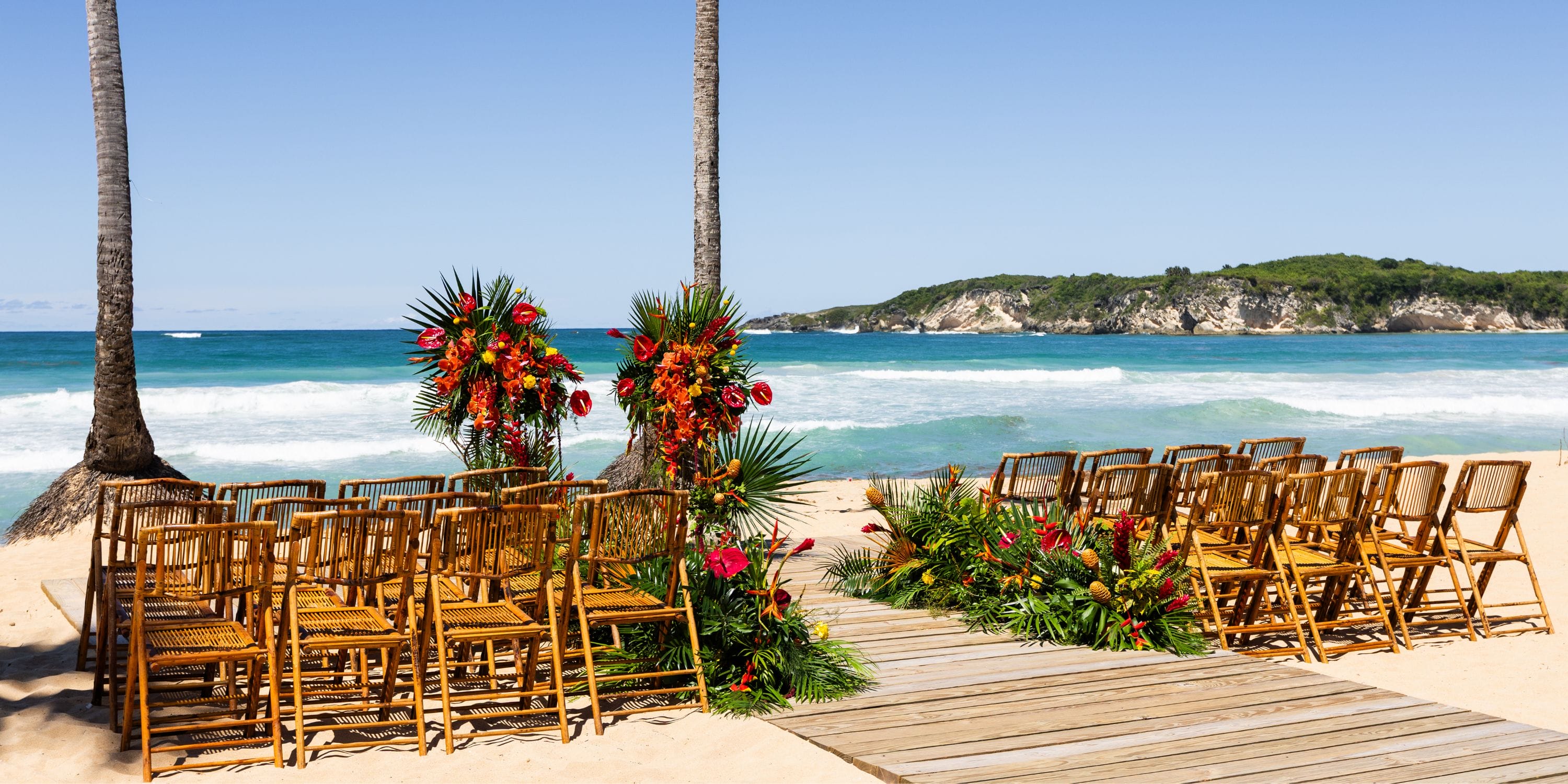 Chairs and flowers arranged for a destination wedding by the ocean at Dreams Macao Beach.