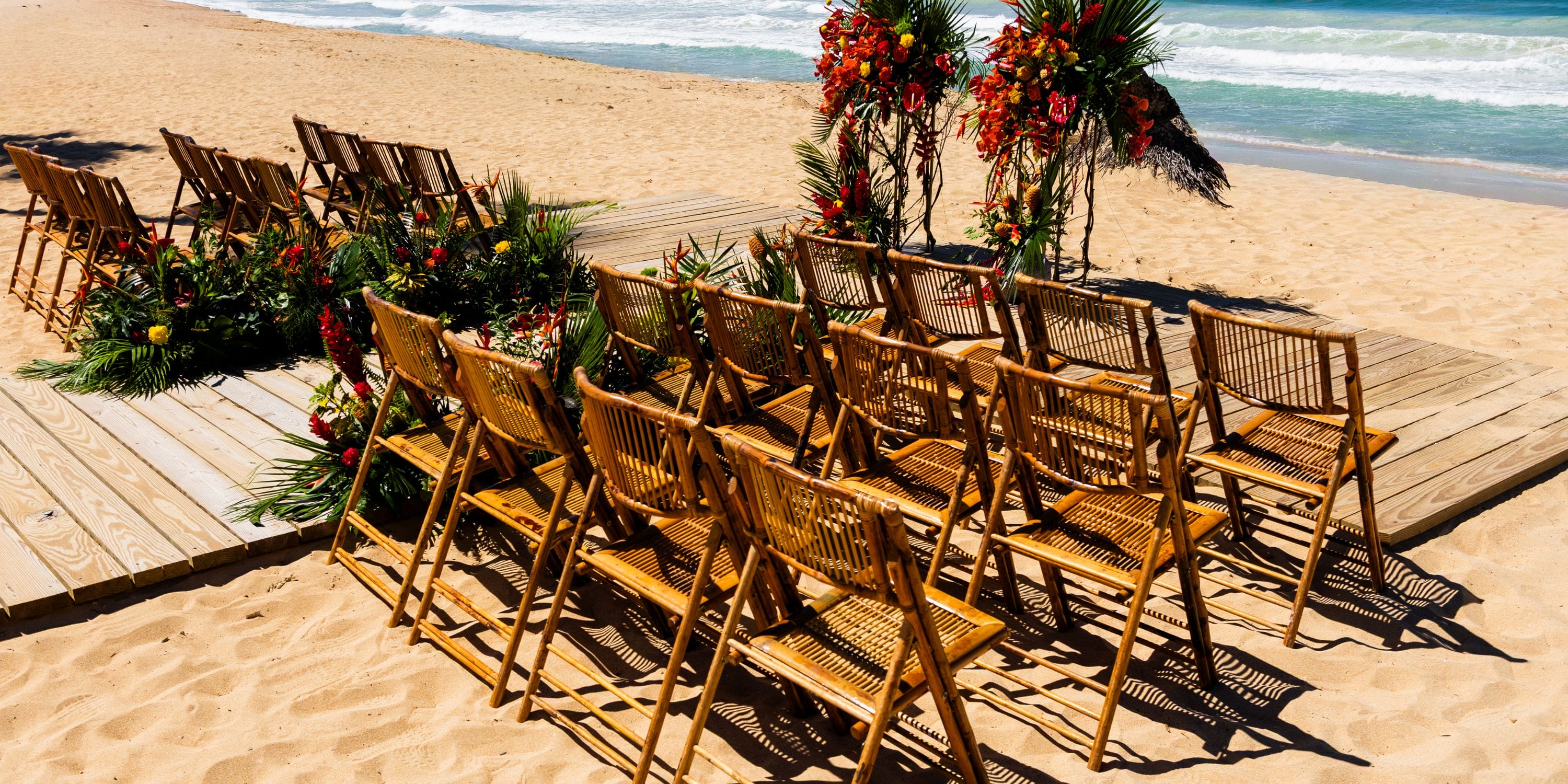 Wooden chairs and florals set up on the sand at Dreams Macao Beach for a destination wedding ceremony.