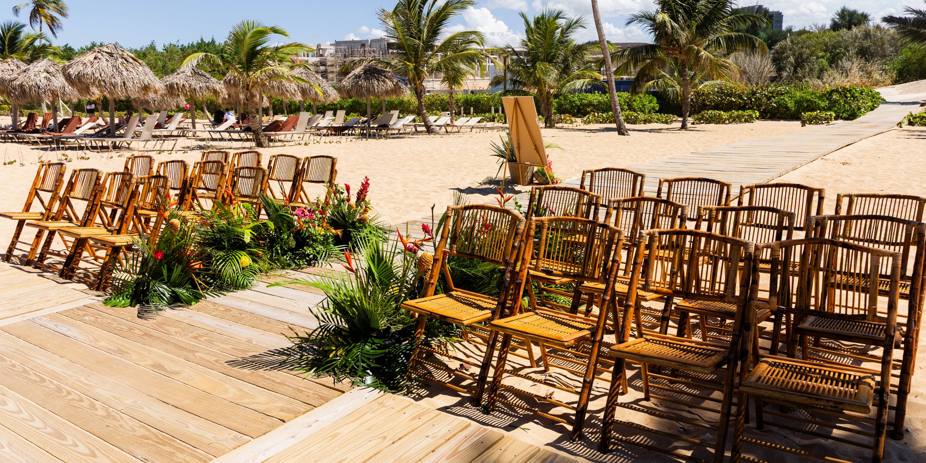 Bamboo chairs arranged on a wooden platform for a destination wedding at Dreams Macao Beach.