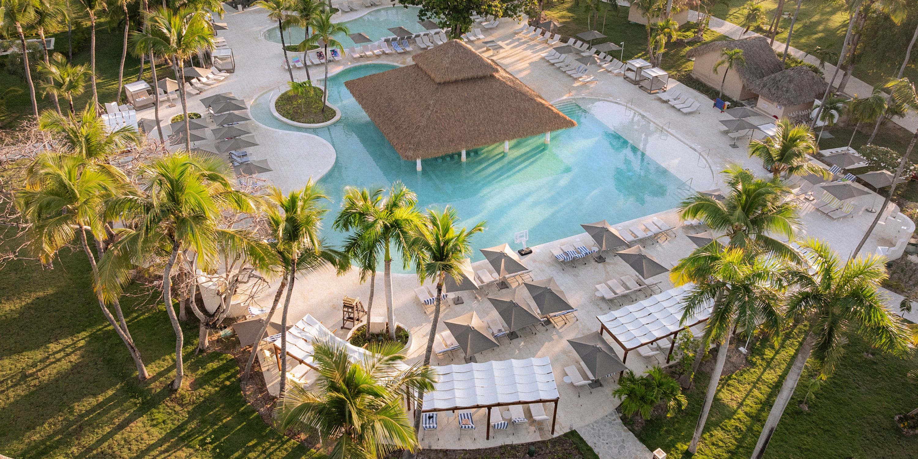 Aerial view of Grand Palladium Bavaro's pool, ideal for a destination wedding with palms and cabanas.