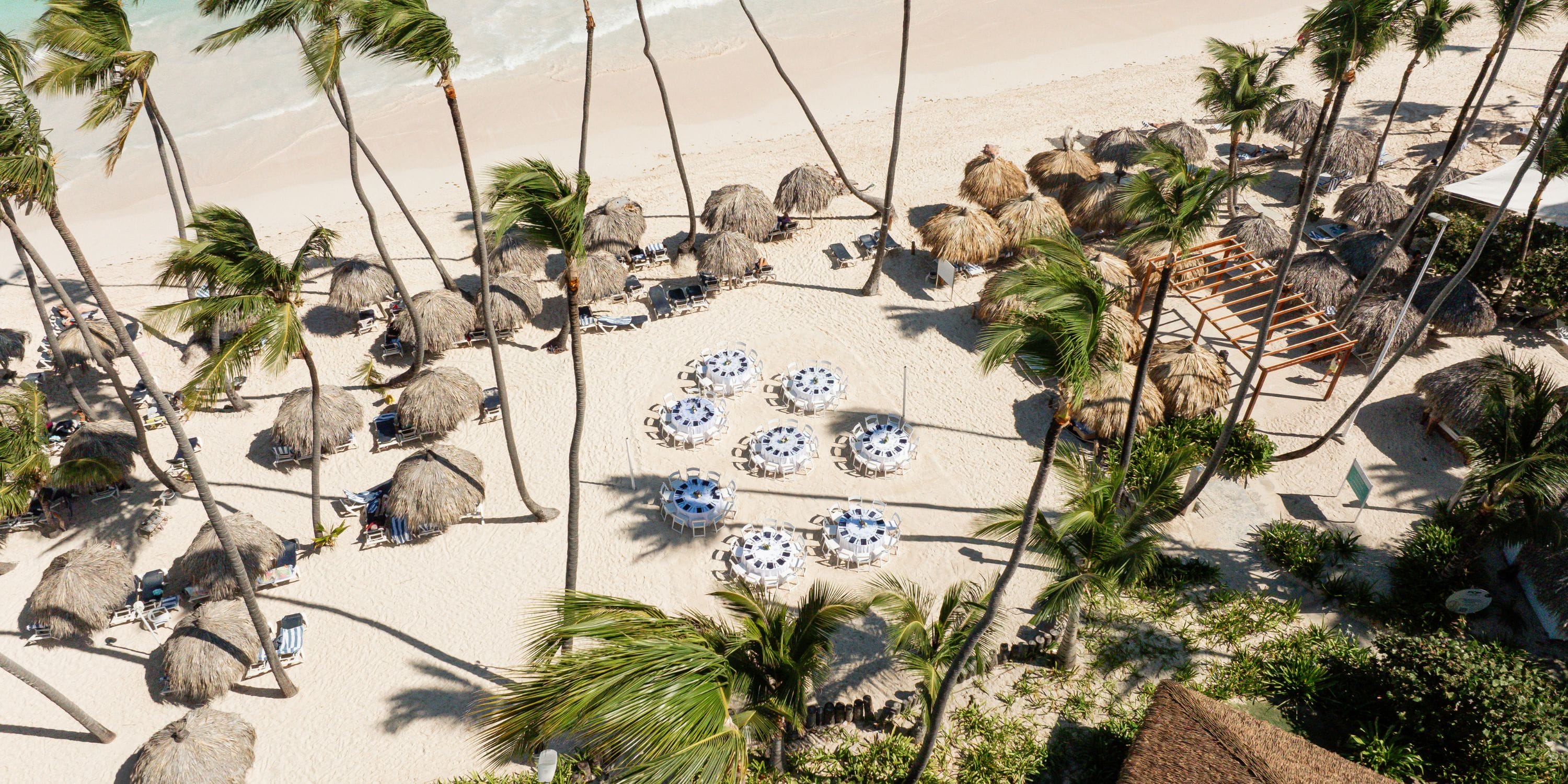 Aerial view of Grand Palladium Select Bavaro, a destination wedding spot with palm trees and umbrellas.