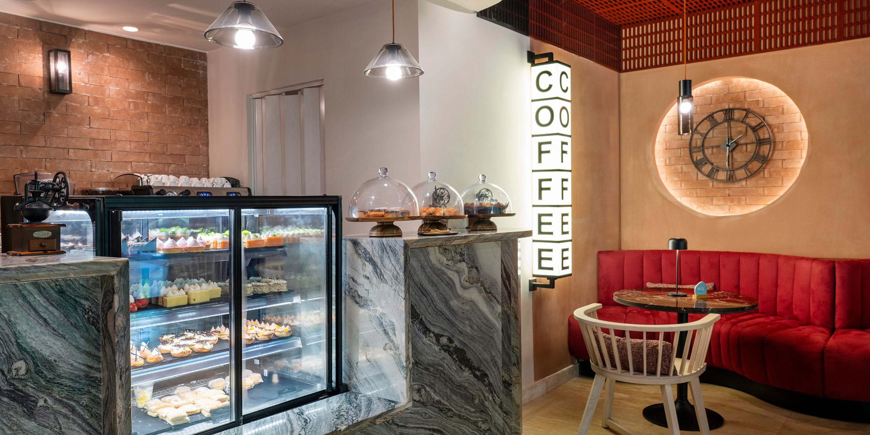 Grand Palladium Bavaro’s modern café, ideal for destination weddings, has dessert displays and red booths.