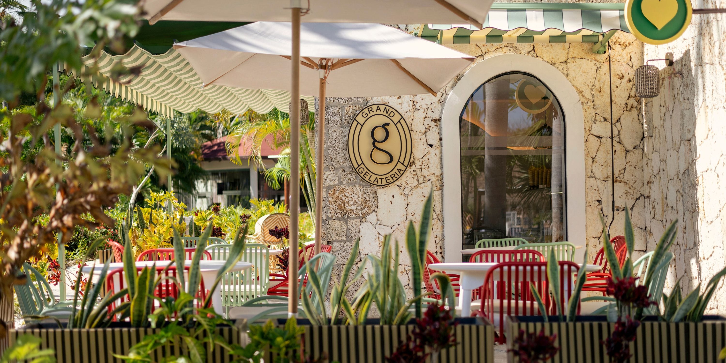 Outdoor seating at Grand Palladium Bavaro for a destination wedding with colorful chairs, umbrellas, and a sign.