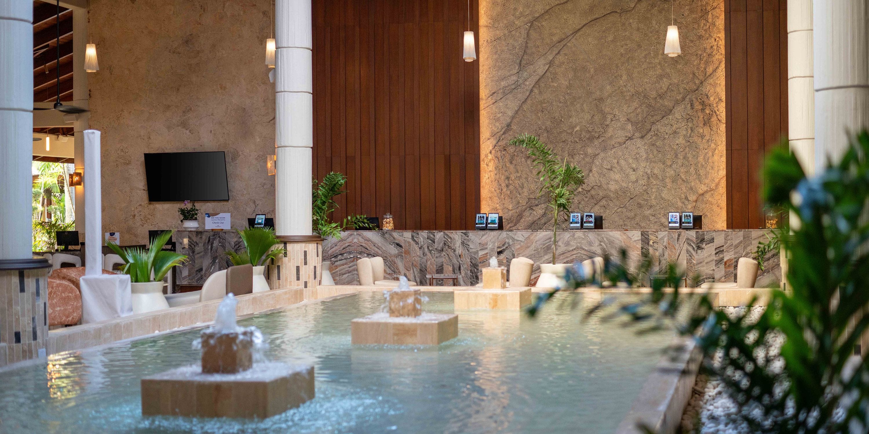 Grand Palladium Bavaro lobby, ideal for a destination wedding, with fountain, seating, and lush plants.