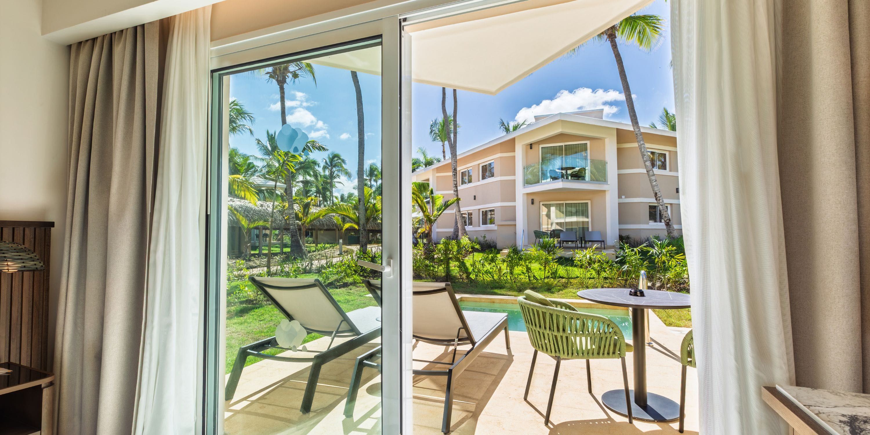 Patio view of pool, lounge chairs, and garden at Grand Palladium Bavaro—ideal for a destination wedding.