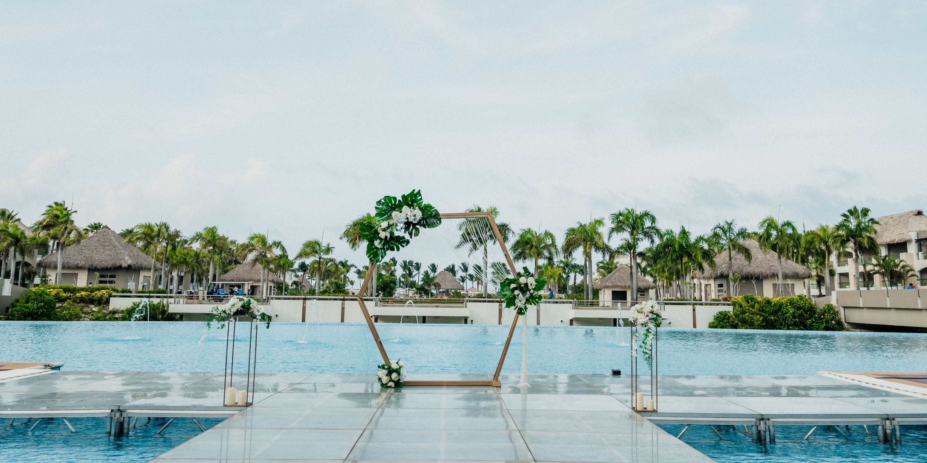 Geometric floral wedding arch at Hard Rock Punta Cana, with pool and palm trees for a destination wedding.