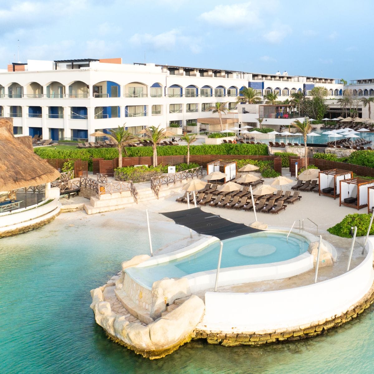 Hard Rock Riviera Maya: a destination wedding resort featuring a pool, lounge chairs, and turquoise water.