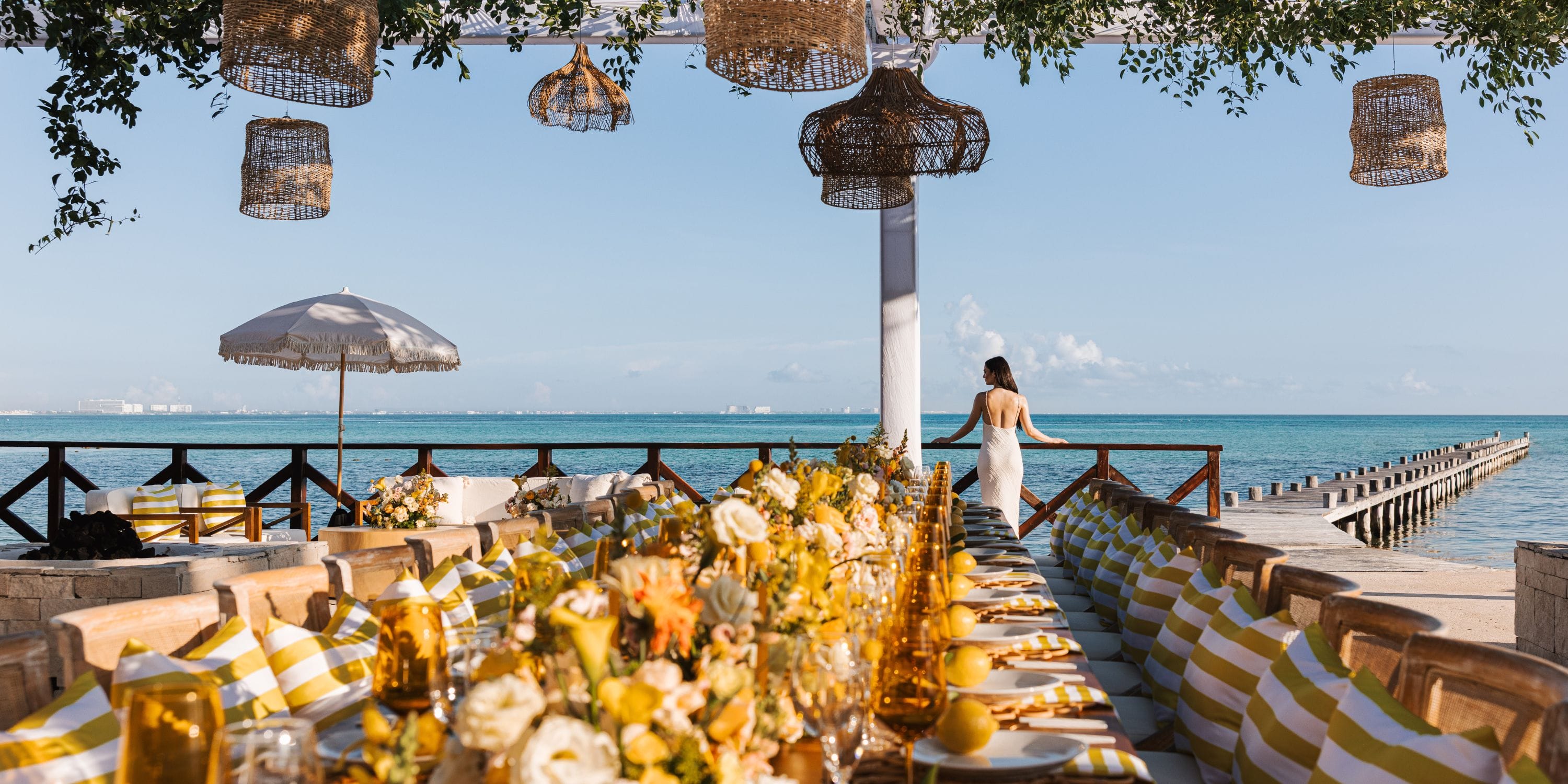 Destination wedding table setup at Hyatt Ziva Cancun by the sea, with a woman near the railing.