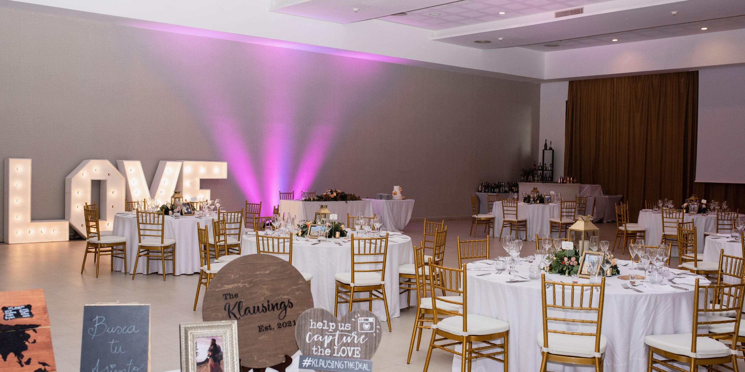 The destination wedding hall at Majestic Elegance Costa Mujeres features round tables, gold chairs, and LOVE letters.