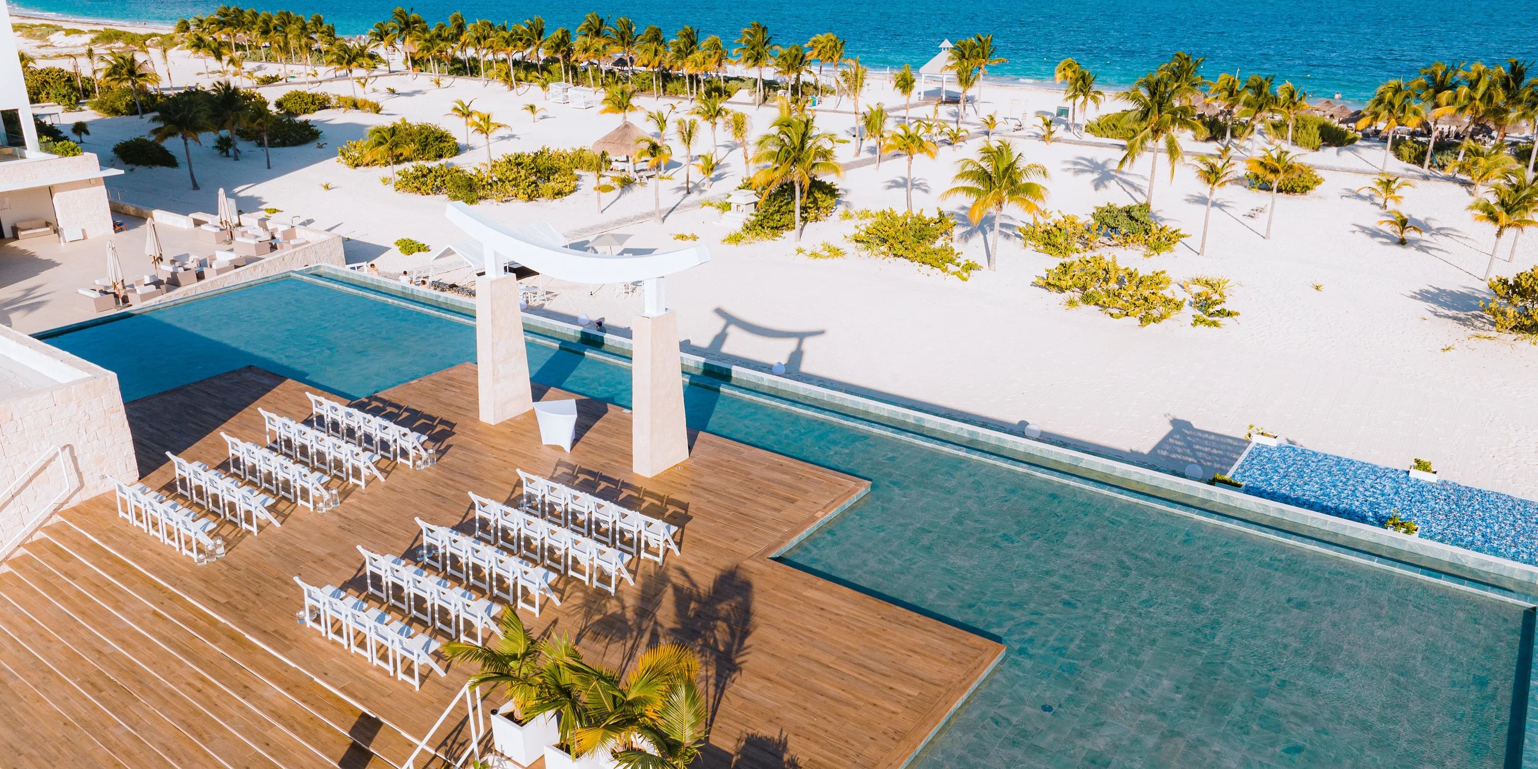 Destination wedding on the deck by the infinity pool at Majestic Elegance Costa Mujeres, overlooking the ocean.