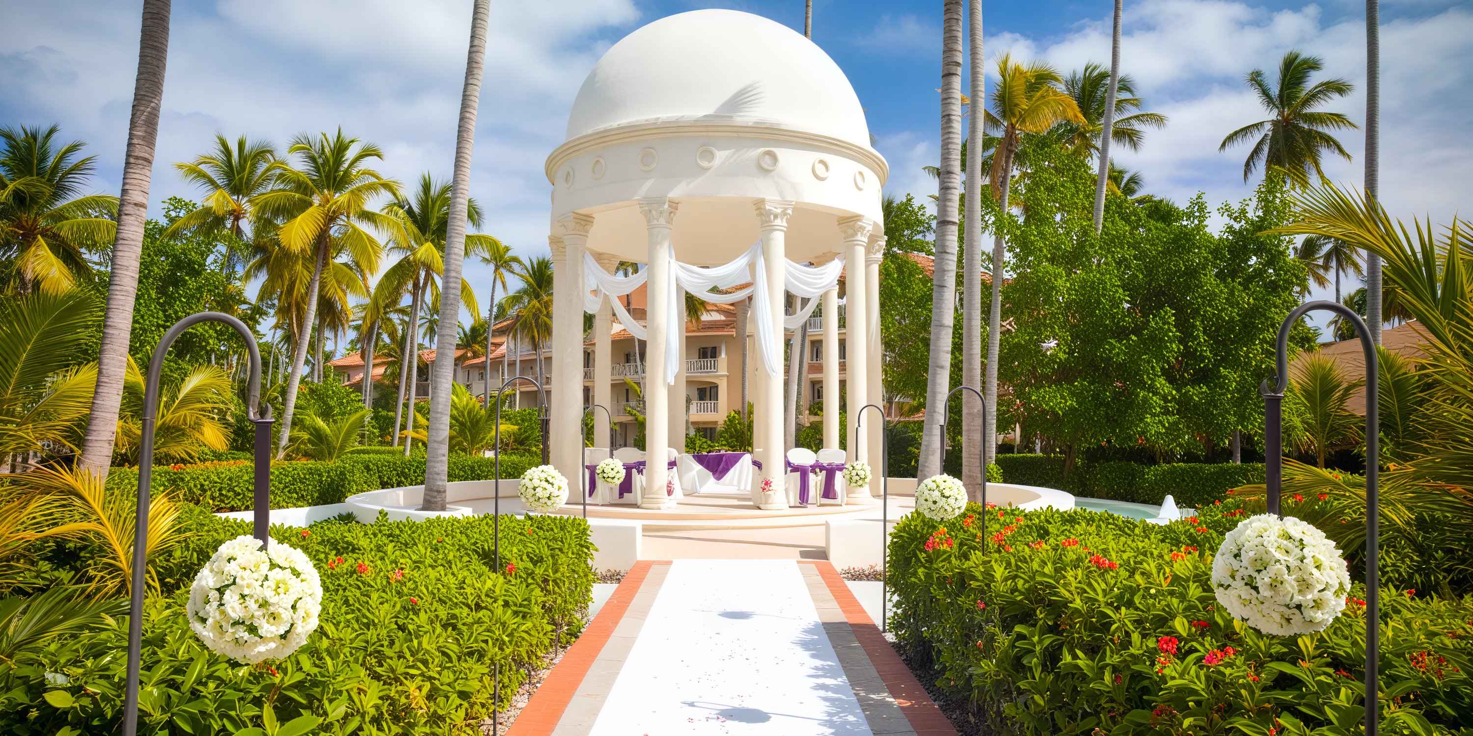 A beautiful destination wedding gazebo nestled amidst lush greenery and swaying palm trees.