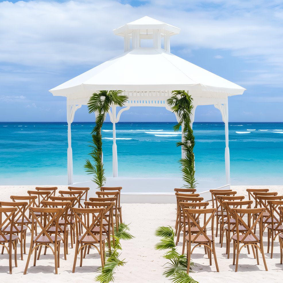 Majestic Mirage destination weddings boast a stunning white gazebo on a sandy beach, complete with ocean-facing chairs.