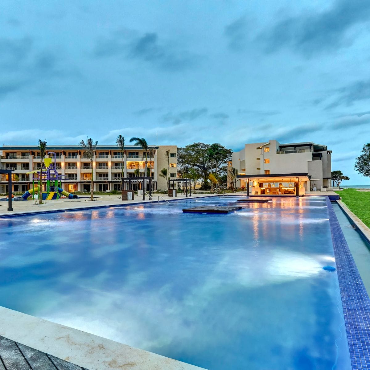 Outdoor pool and bar at dusk create a romantic Royalton Negril destination wedding atmosphere.