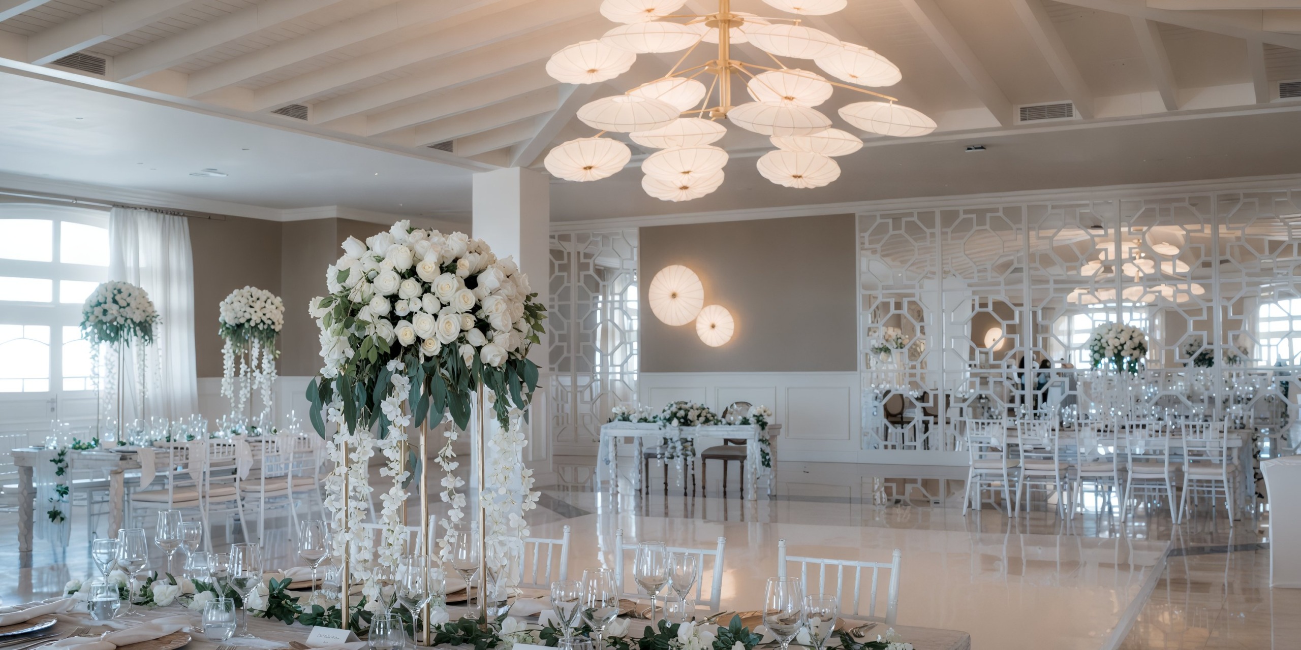 Exquisite destination wedding reception at Majestic Elegance, adorned with white flowers and shimmering chandeliers.