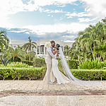A bride and groom kiss in front of Dreams Tulum.