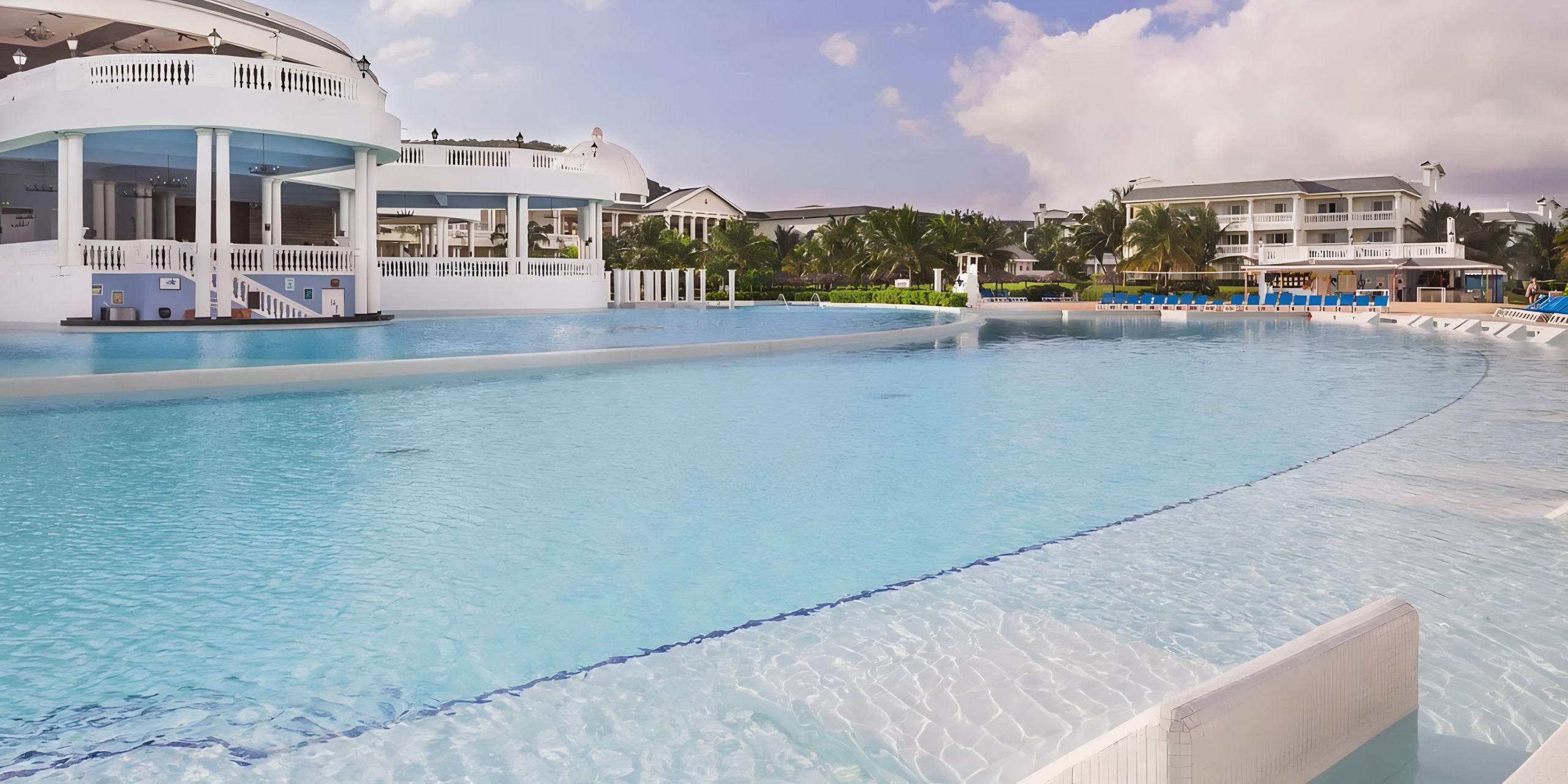 Luxury Grand Palladium Lady Hamilton resort with expansive outdoor pool and white buildings under a cloudy sky, perfect for a wedding.