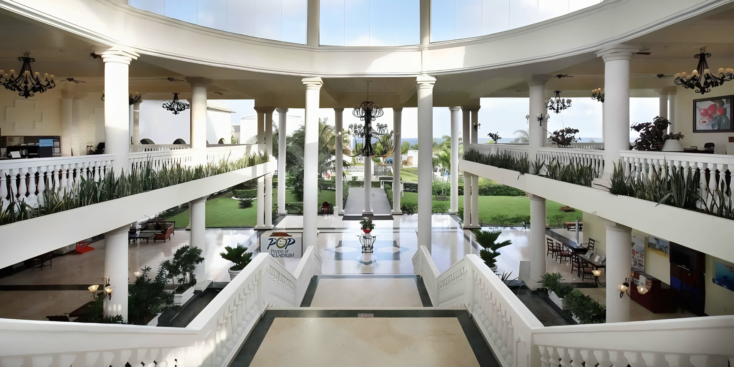 Symmetrical view of the Grand Palladium Lady Hamilton's grand hotel lobby with twin staircases leading down to a main foyer, perfect for wedding photos.