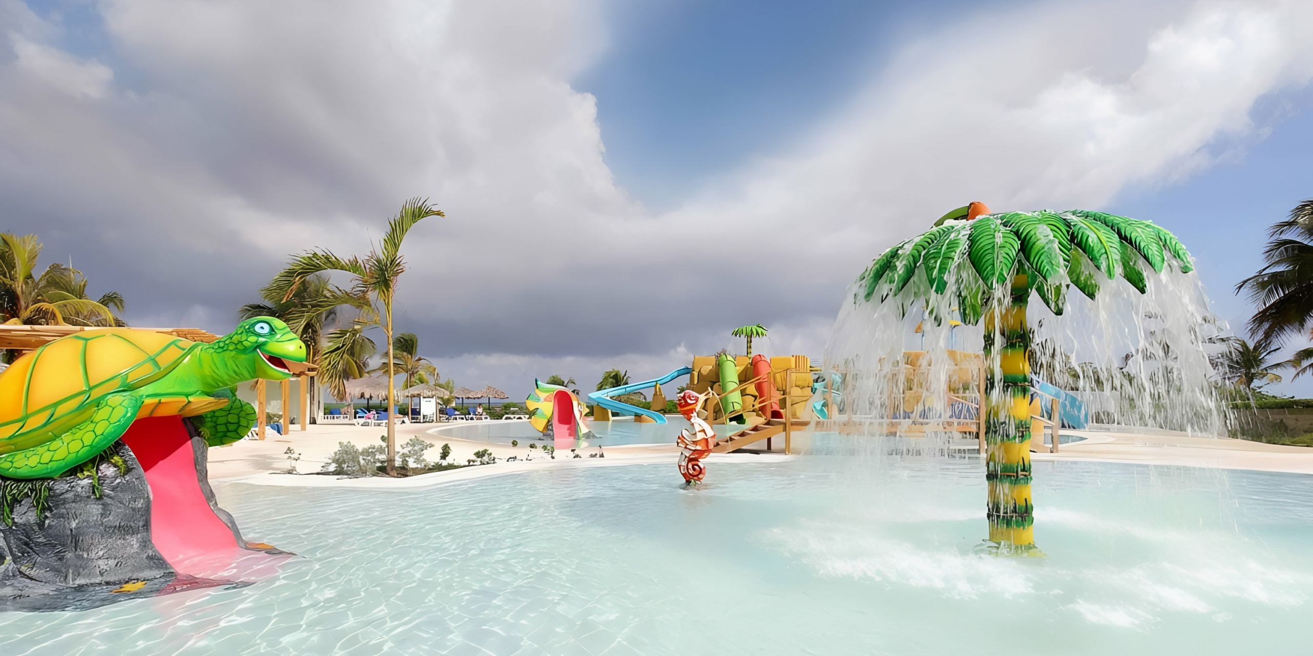A colorful water park with playful animal-themed structures and a Wedding Pavilion palm tree fountain under a partly cloudy sky.