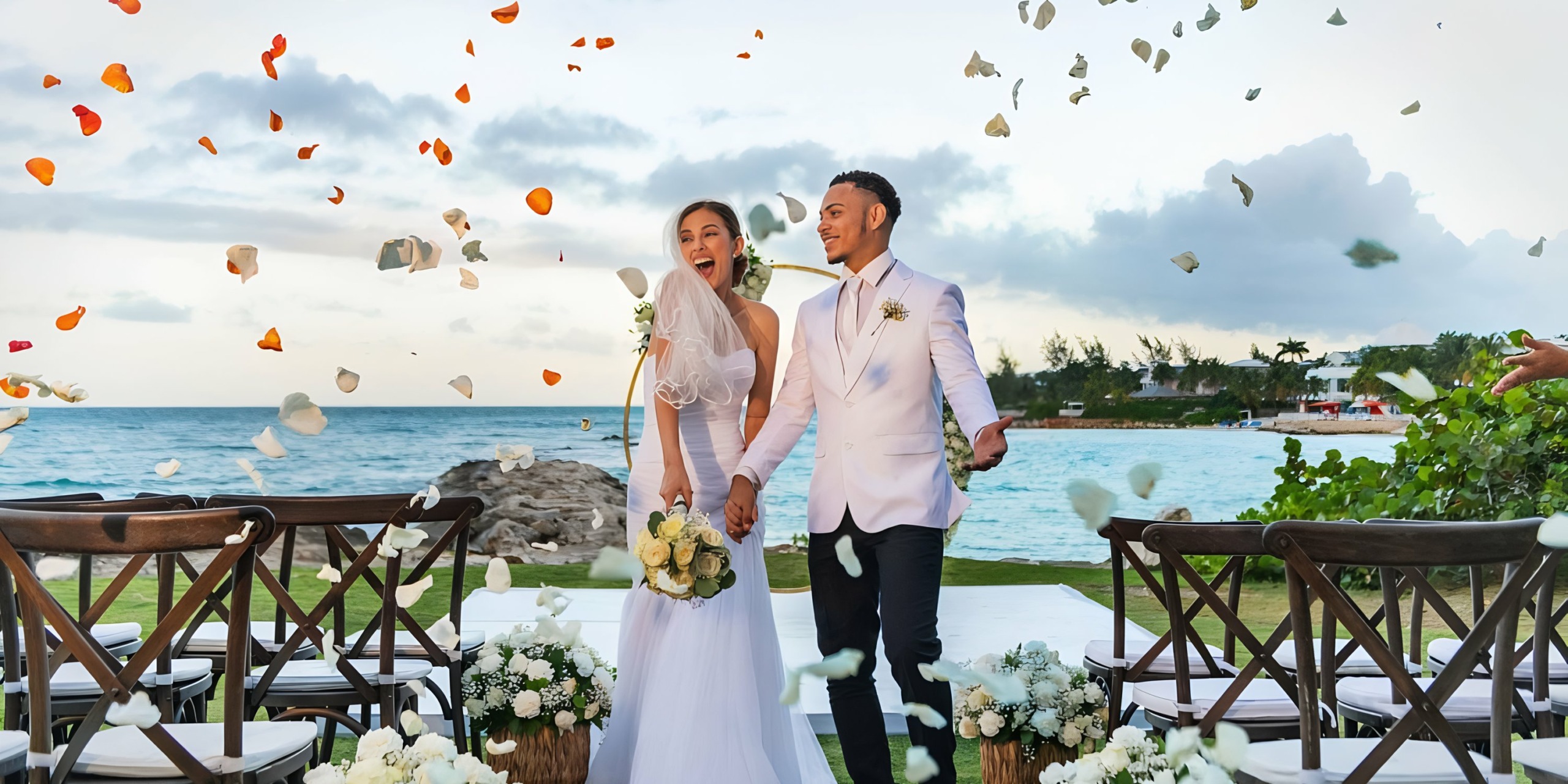 A joyful bride and groom are showered with petals during their Palladium Lady Hamilton beachside wedding celebration.