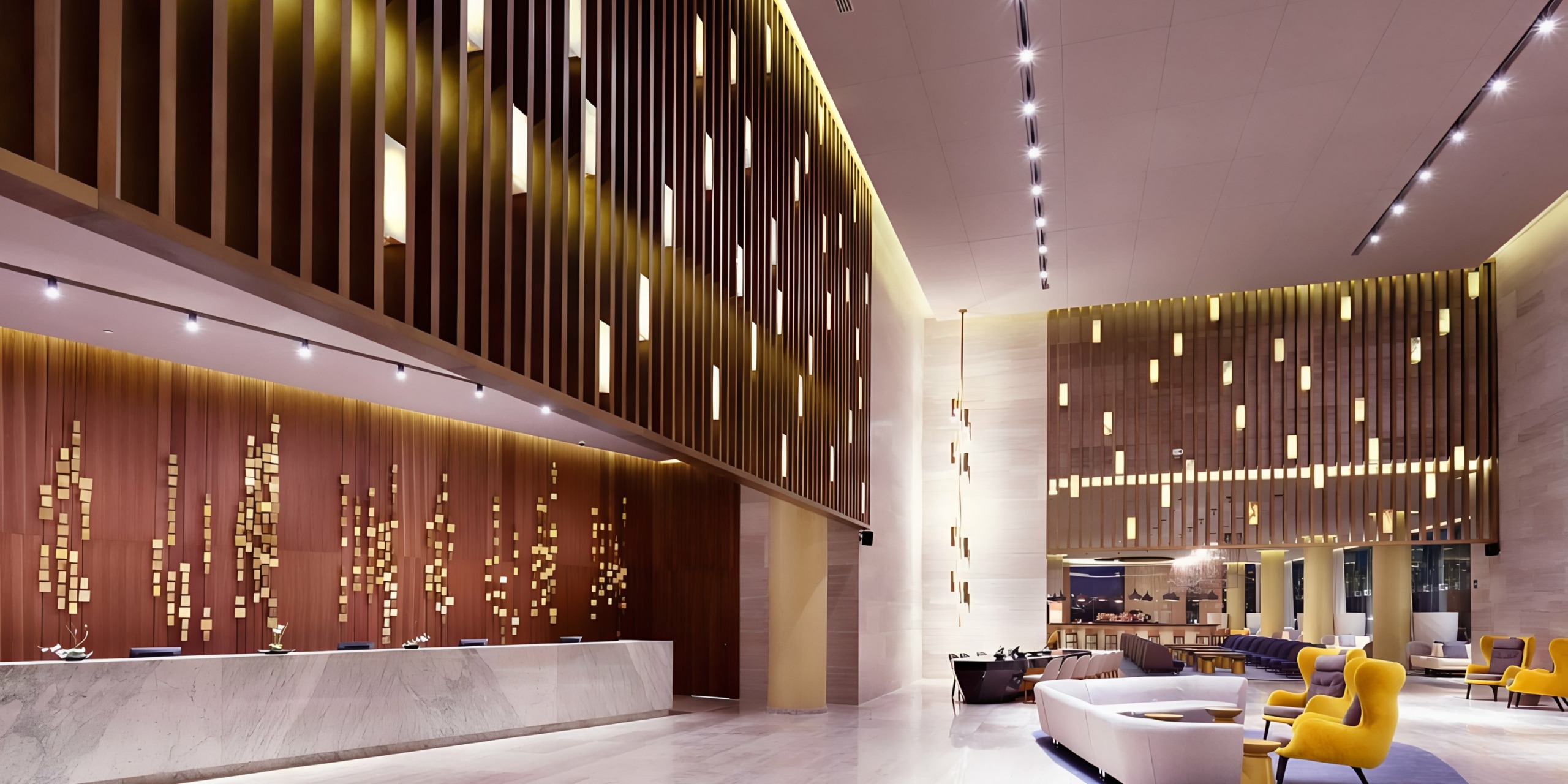 Modern hotel lobby at Grand Palladium Costa Mujeres with a reception desk, wooden accent walls, and contemporary seating area.