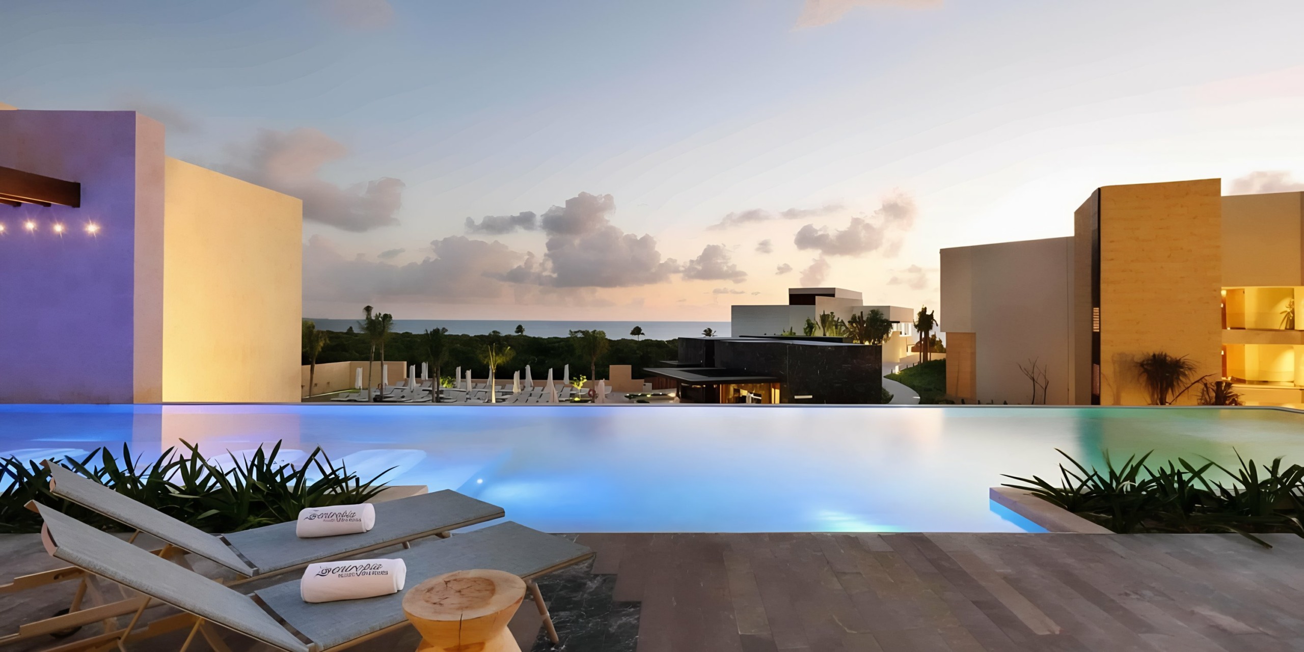 Grand Palladium Costa Mujeres poolside lounging area at dusk with modern architectural elements and tranquil sky.