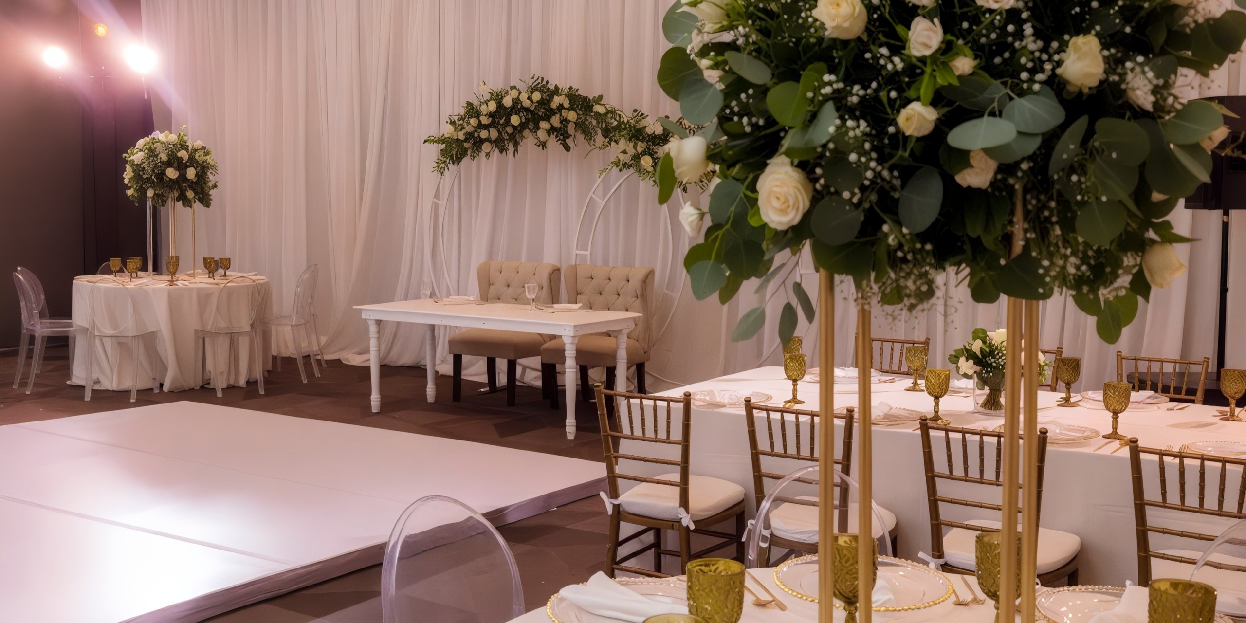 Experience an elegant wedding reception setup at Grand Palladium Vallarta, featuring white tables, gold chairs, stunning floral centerpieces, and a spacious dance floor.