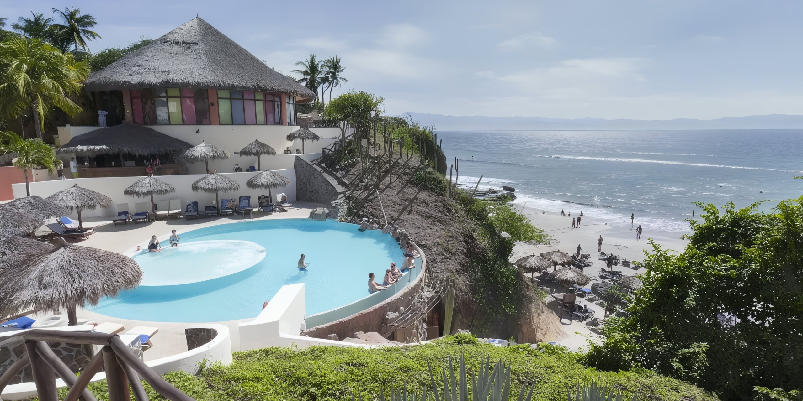 The Grand Palladium Vallarta is a beachfront resort with a circular pool offering stunning ocean views. Guests are relaxing by the pool and on the beach, while the thatched-roof building is surrounded by lush tropical greenery.