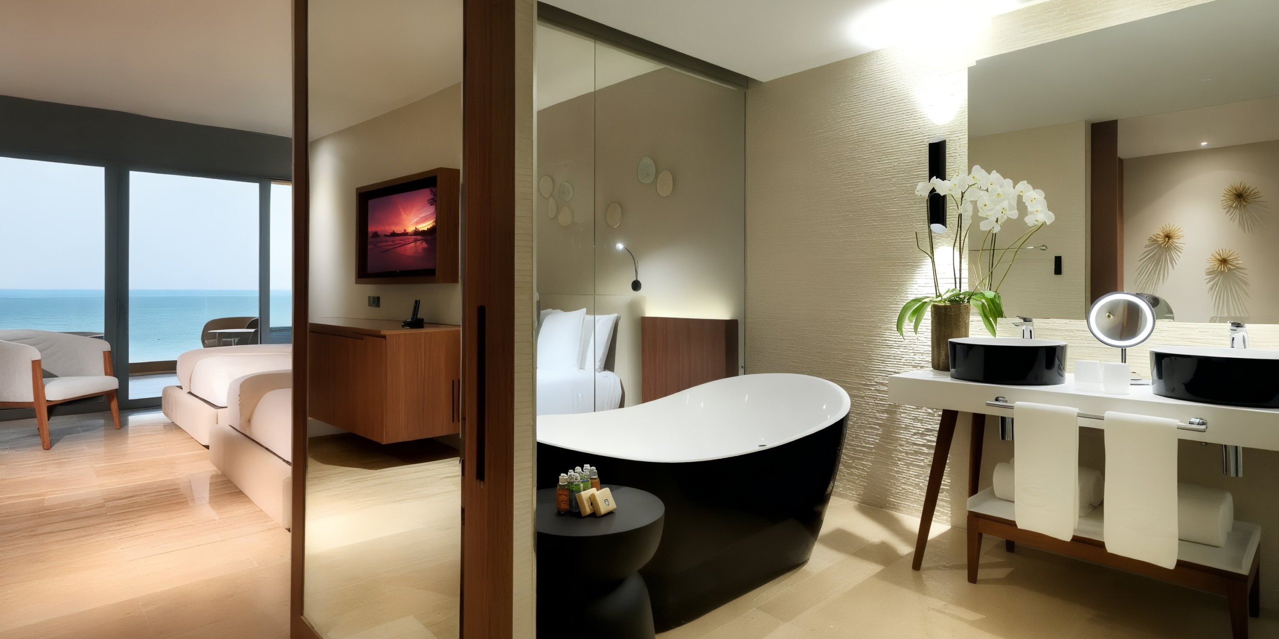 Enjoy a modern room at the Grand Palladium Costa Mujeres offering stunning ocean views, complete with a king-sized bed, a bathroom equipped with a freestanding tub and double sinks, all set against contemporary decor.
