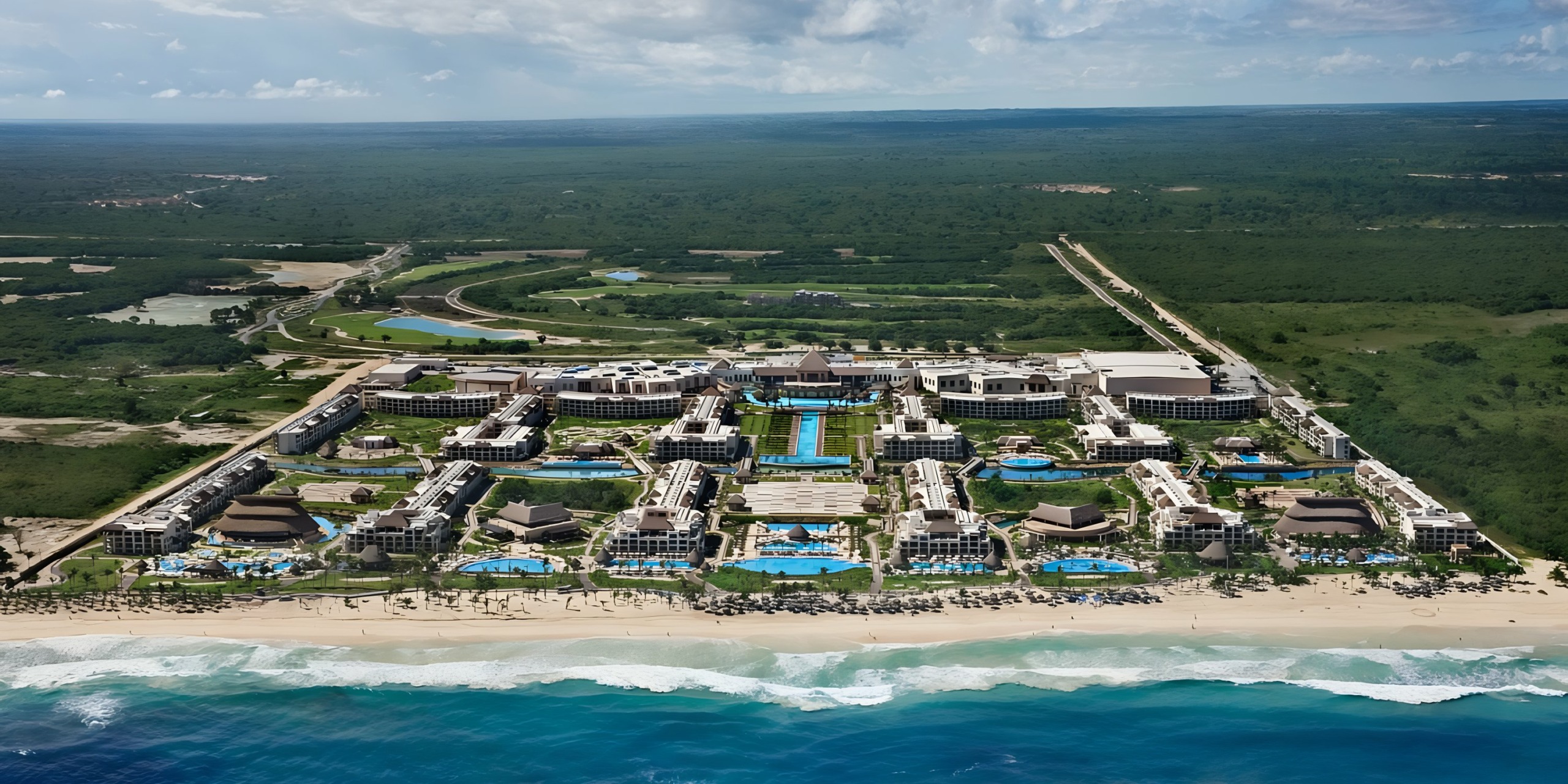 Aerial view of Hard Rock Punta Cana with multiple swimming pools and beachfront access.