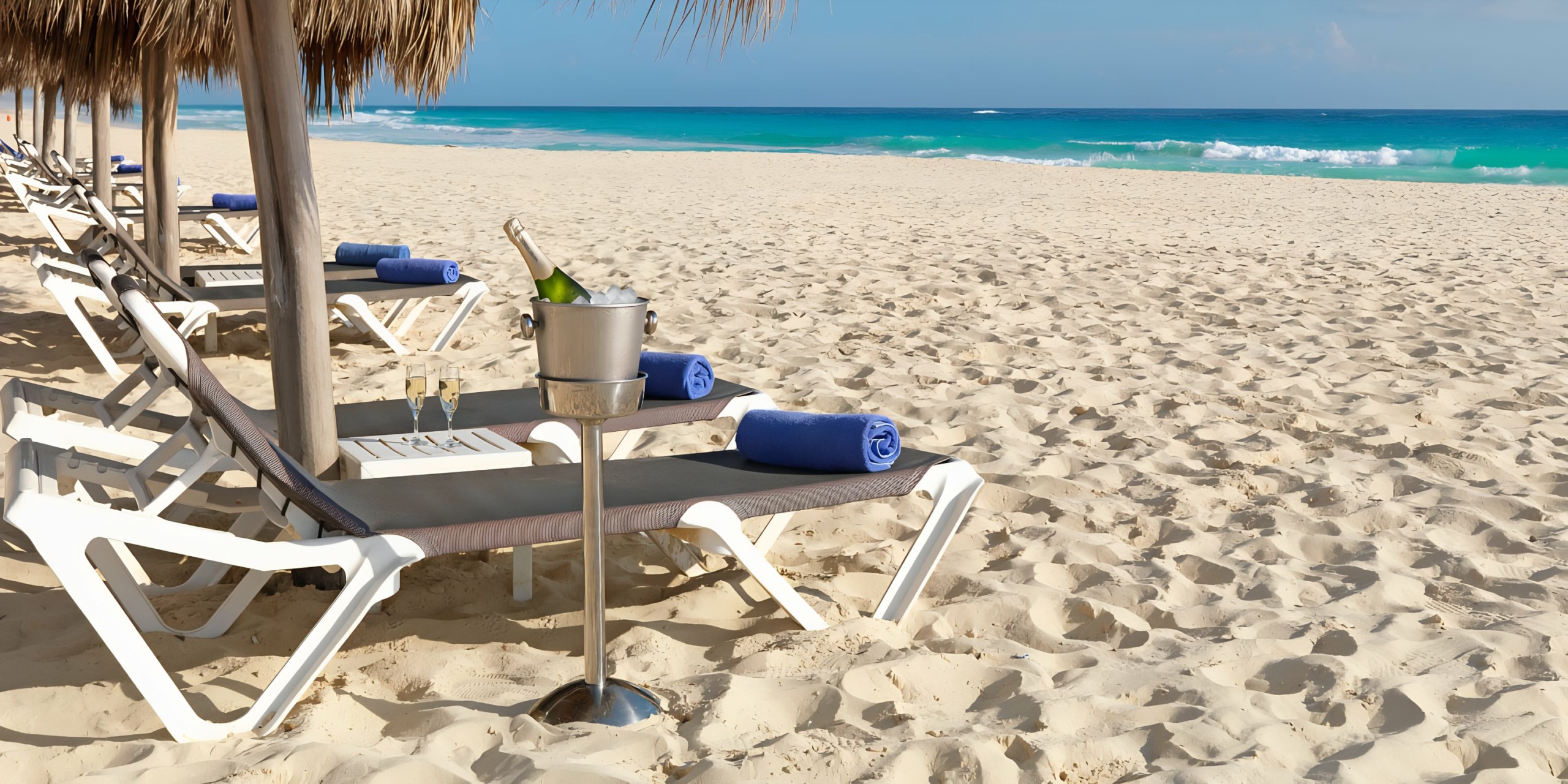 Hard Rock Punta Cana and a cooling bucket on a sandy beach with a view of the turquoise sea.