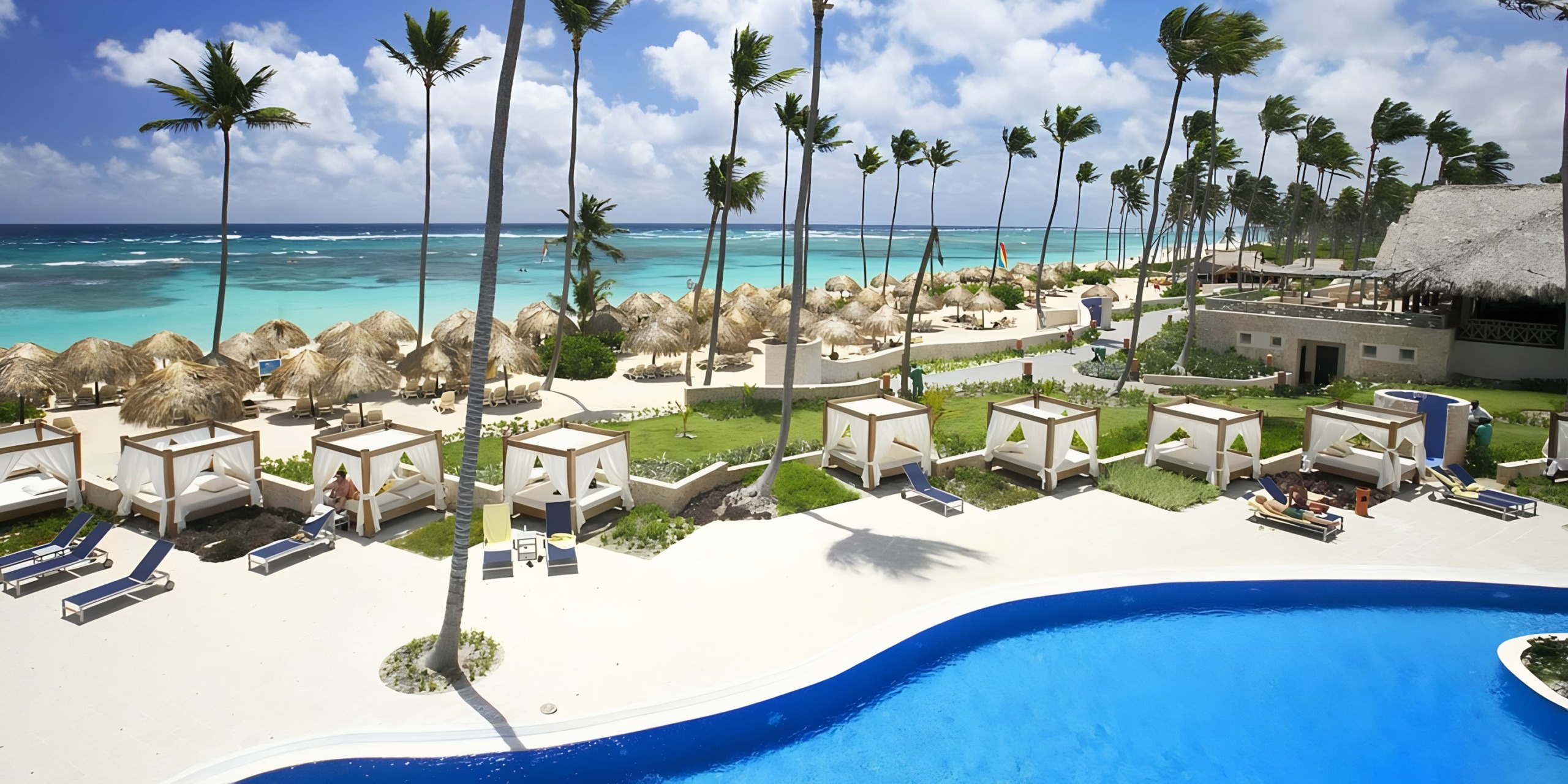 Majestic Elegance Punta Cana beach resort with cabanas, palm trees, and a swimming pool overlooking a turquoise sea.