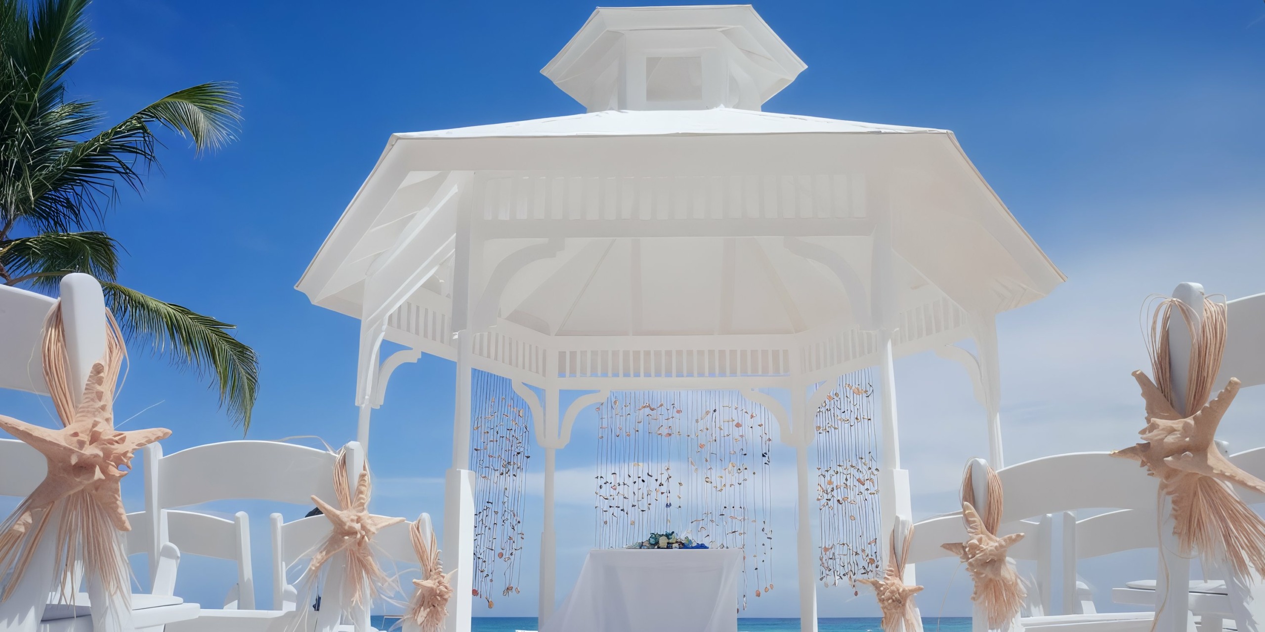 The Majestic Elegance Punta Cana, adorned with ribbons and floral arrangements, is set up for an outdoor event under a clear blue sky.