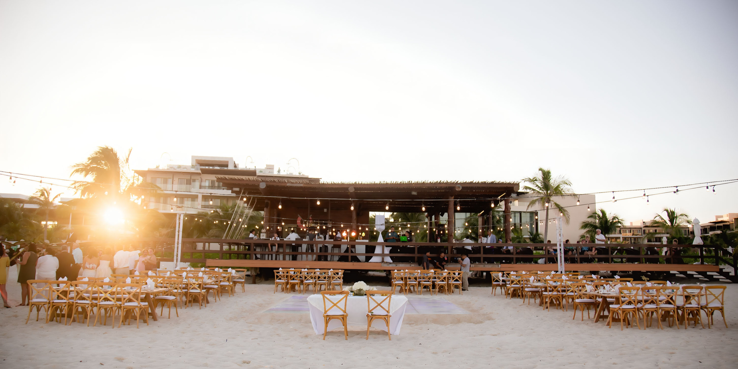 A Royalton Riviera Cancun wedding ceremony set up on the beach at sunset.