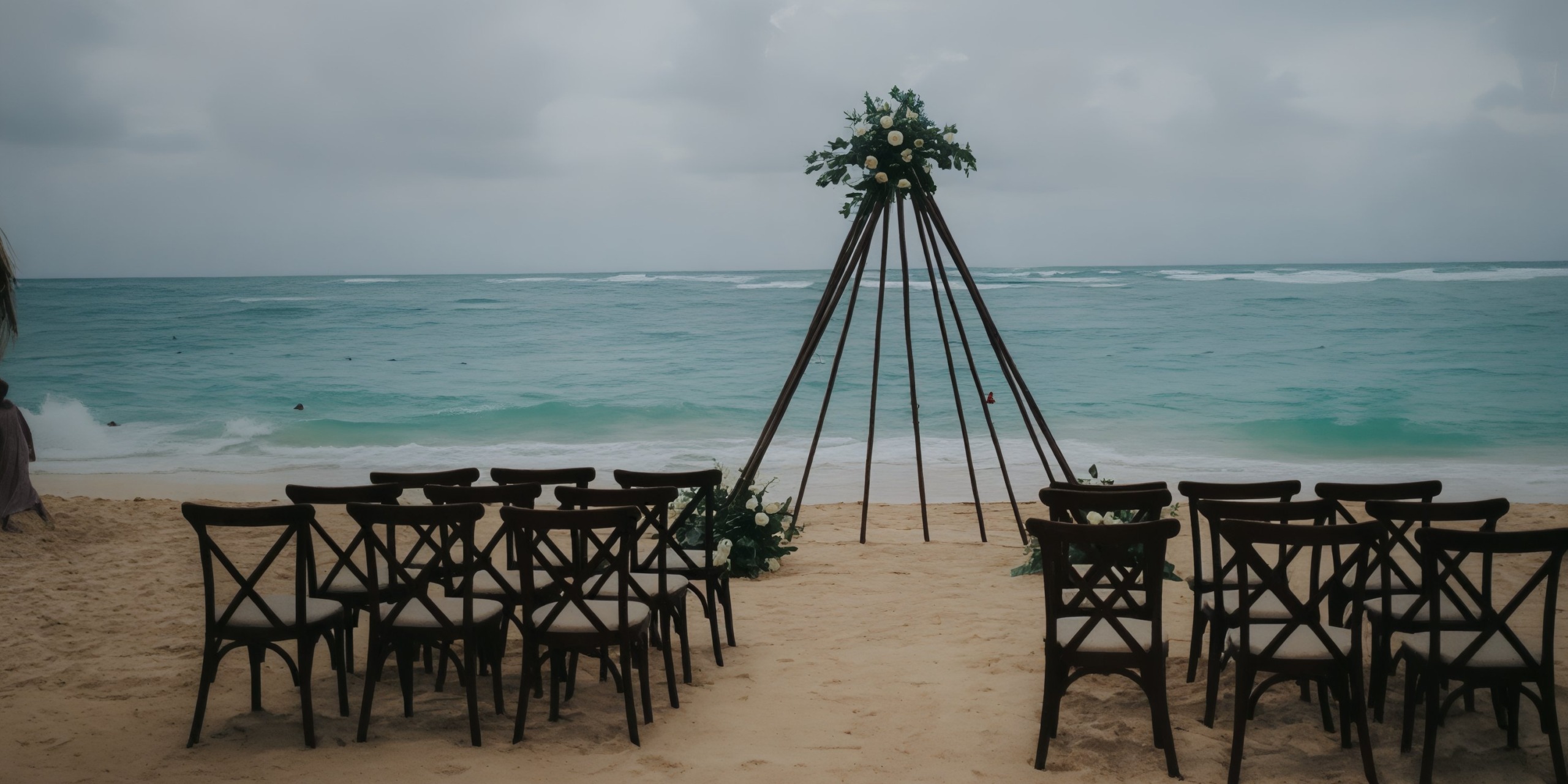 On the beach at Royalton Bavaro, chairs are elegantly arranged to face a beautiful floral arch by the sea, creating the perfect setting for a dreamy destination wedding.