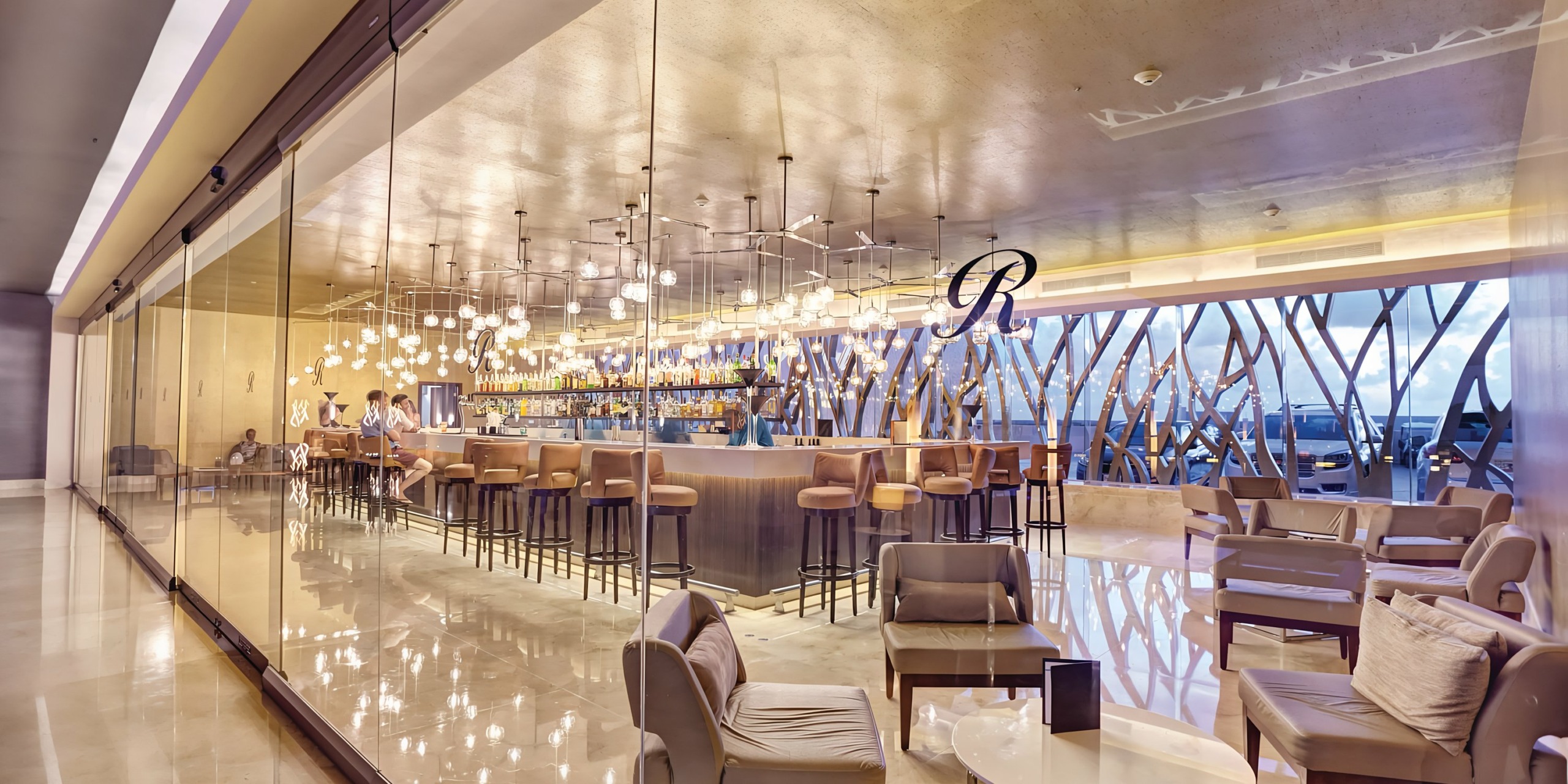 Interior of a modern bar with stylish lighting and seating arrangements, perfect for a Royalton Riviera Cancun wedding.