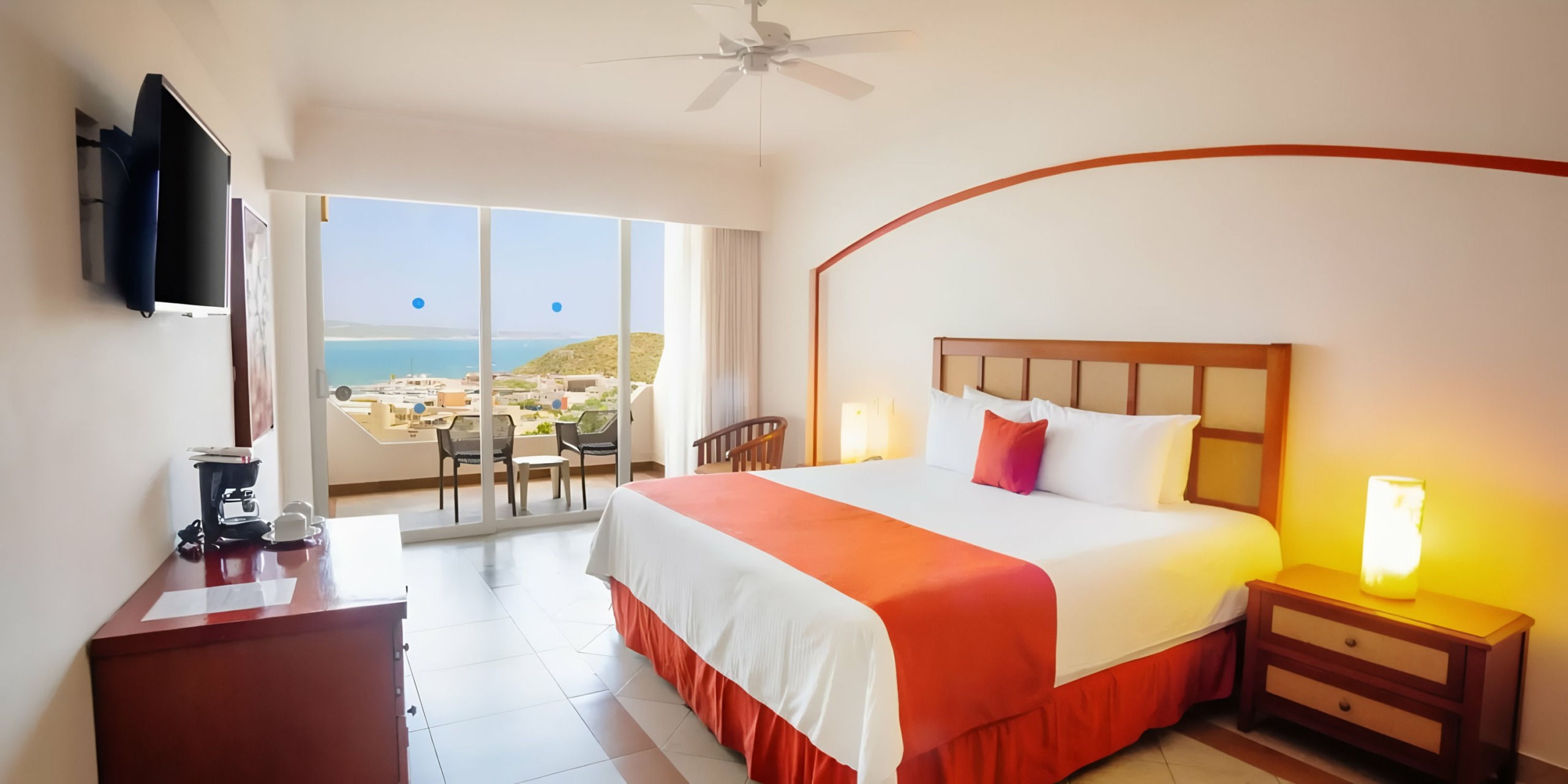 Sandos Finisterra Los Cabos hotel room with a king-size bed offering a sea view from its balcony.