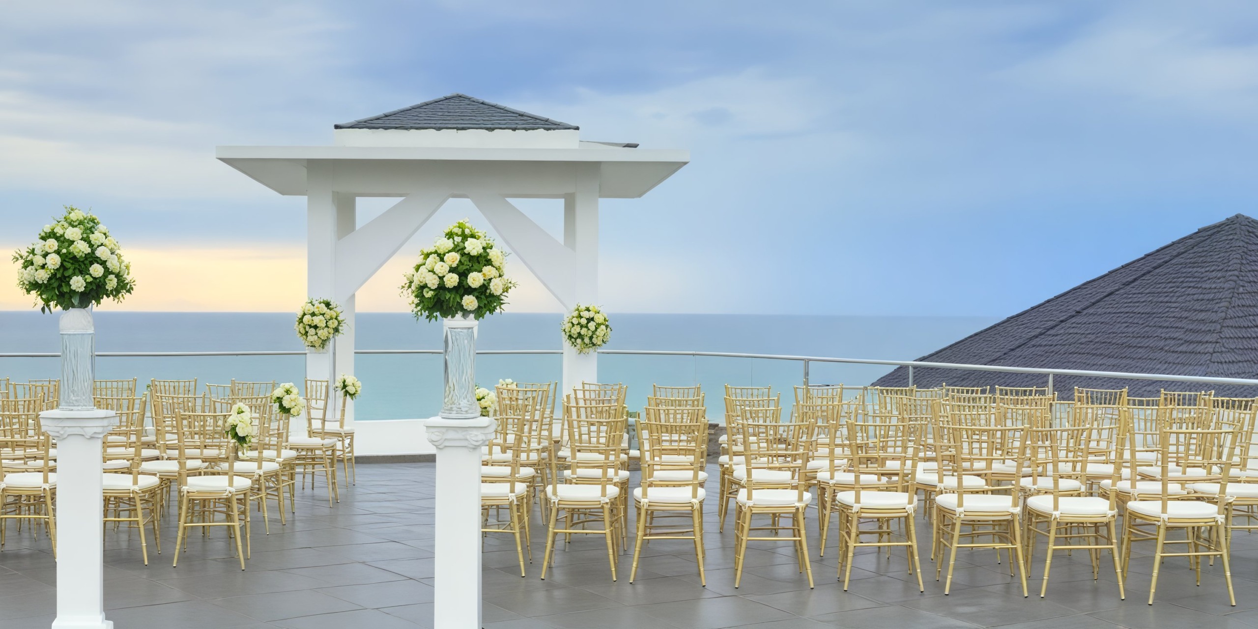 Experience a breathtaking destination wedding setup at Azul Beach Resort Negril, featuring elegantly arranged chairs, stunning floral decorations, and a mesmerizing ocean view.
