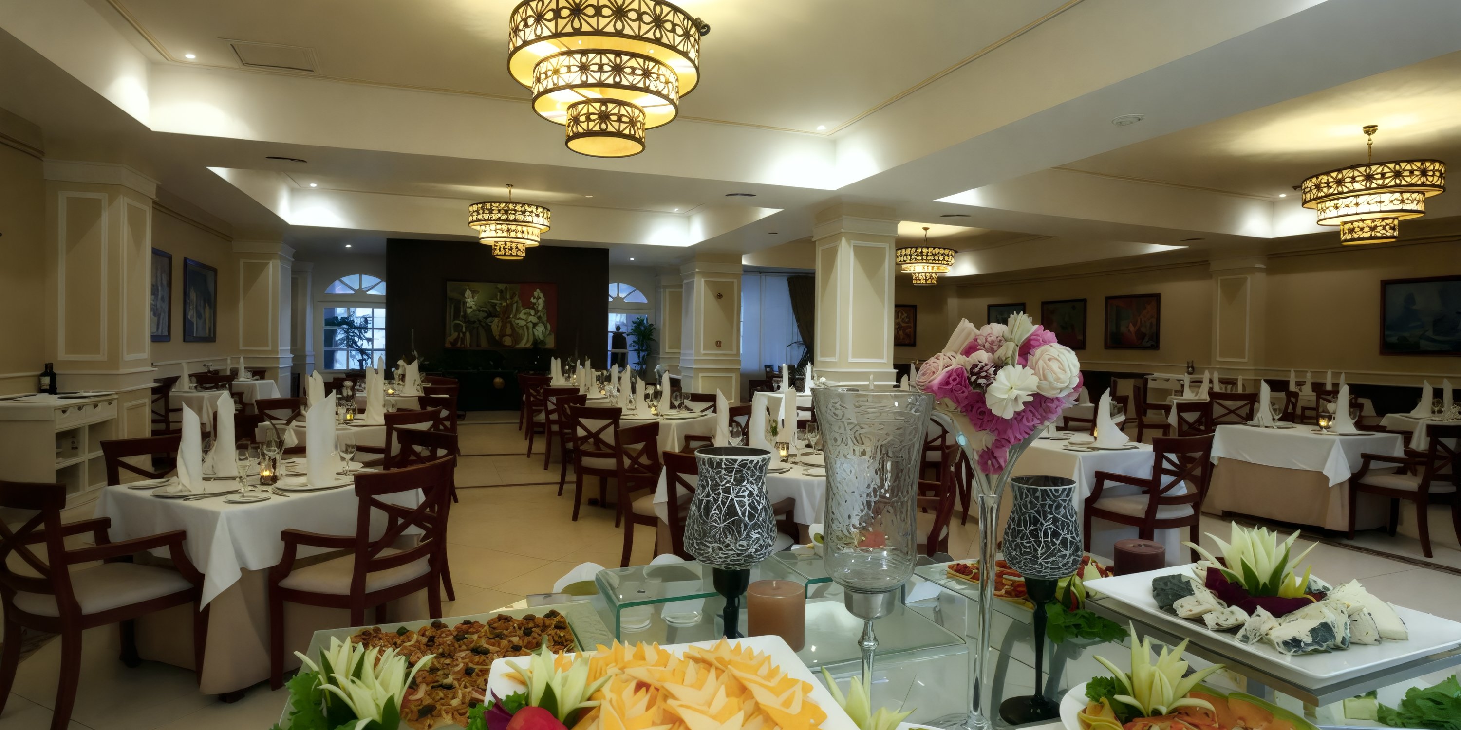 The Bahia Principe Luxury Runaway Bay provides a sophisticated dining experience, complete with chandeliers and meticulously arranged tables, making it an ideal setting for a destination wedding.